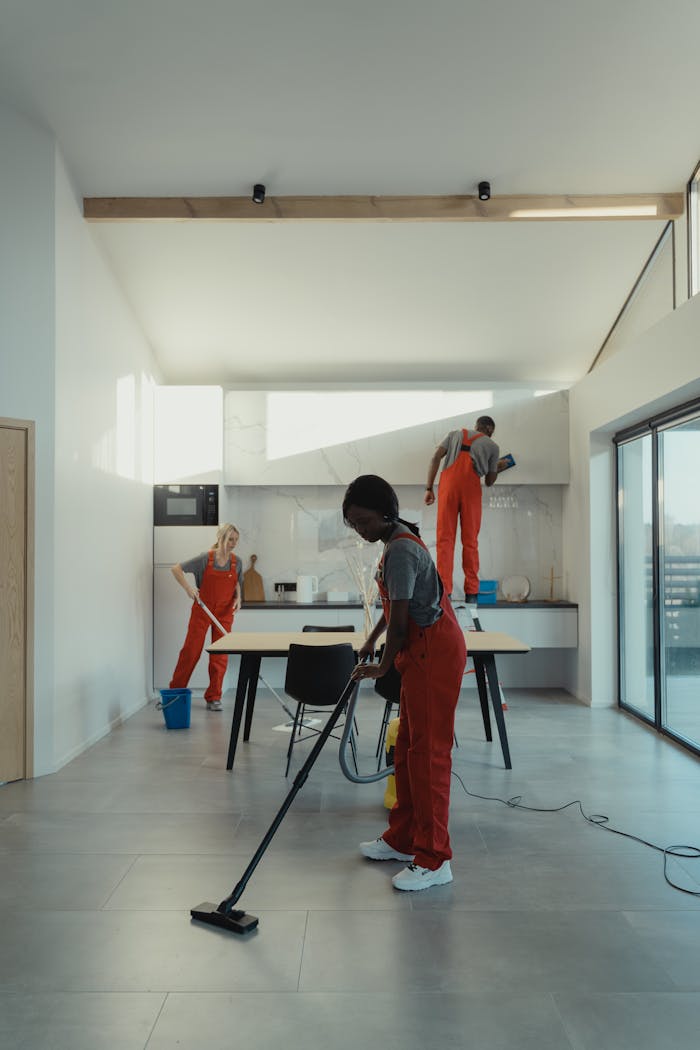 A diverse group of professionals cleaning a modern home interior.